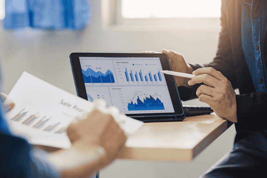 Manager analizzano grafici di flusso di cassa su tablet e report finanziari.