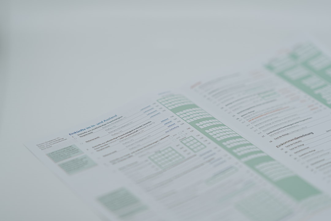 Persona che tiene in mano due documenti finanziari, immagine che rappresenta il confronto tra pagine dell’estratto conto della carta di credito.