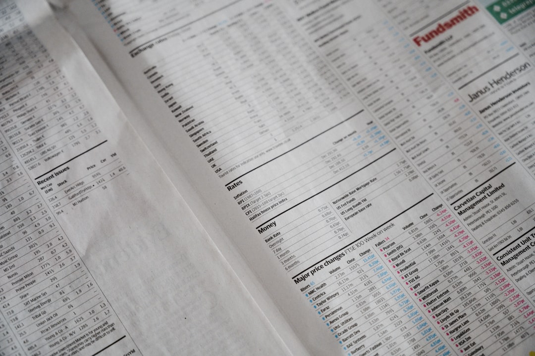 Persona che usa una calcolatrice accanto a un laptop per controllare documenti, immagine collegata alla lettura dell’estratto conto della carta di credito.