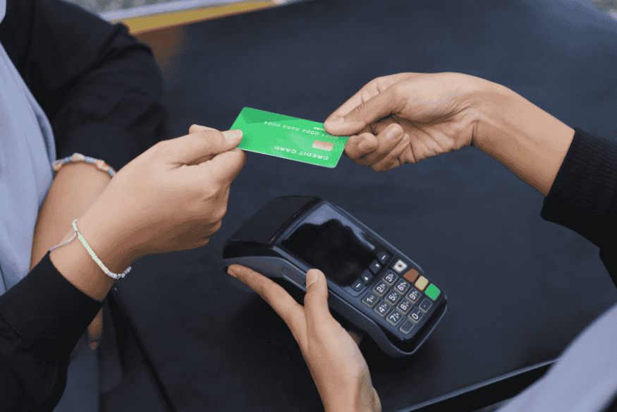 Due persone che completano un pagamento con carta verde su terminale POS.