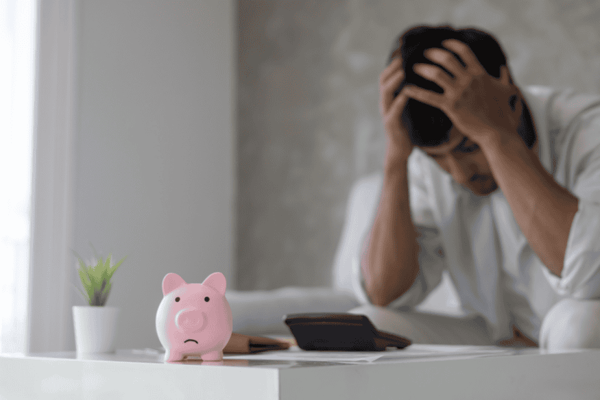 Persona stressata con salvadanaio: il risparmio automatico riduce l’ansia finanziaria e crea abitudini costanti.