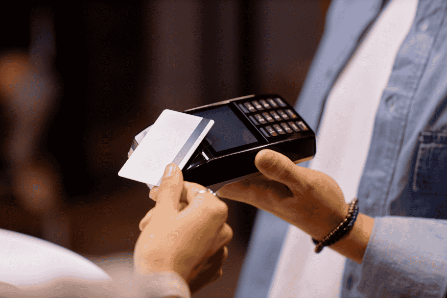 Cliente che effettua un pagamento con carta bianca su POS portatile in negozio.