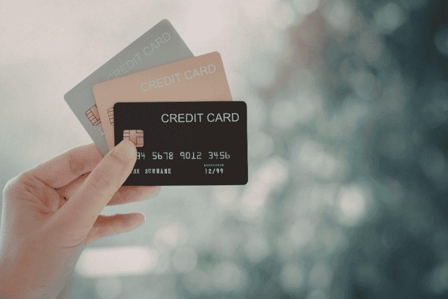 Mano che tiene più carte di credito, immagine collegata alla scelta tra diverse carte di credito a rate e al confronto dei costi prima della richiesta.