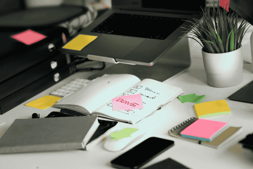 Scrivania con agenda e post-it “Done”, concetto di pianificazione del budget dopo il primo stipendio.